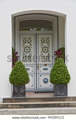 Grey double door with plants in flower pots on the stairs. Shot from Friedrichstadt, Germany