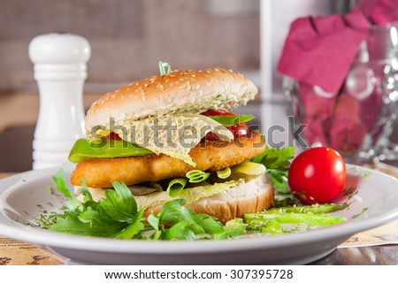 Close up big burger with beef fillet with paneer, cheese and vegetables on the white plate on served restaurant table