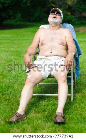 A funny picture of an older shirtless man sleeping in a folding chair.