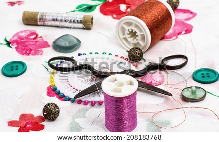 thread for sewing,buttons,scissors on a light background