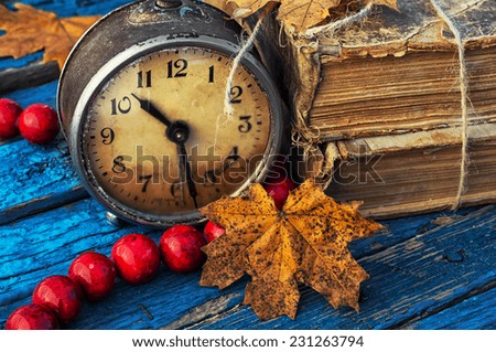 old-fashioned alarm clock and coral beads on a light blue wooden background
