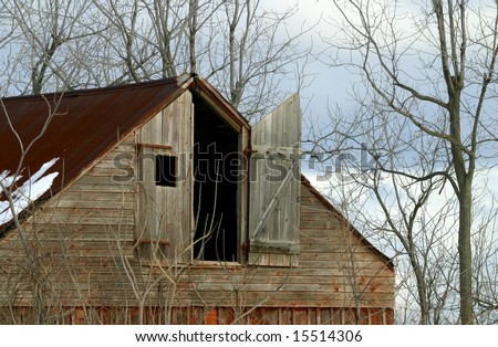 Old Barn in Winter with door open in the Wind