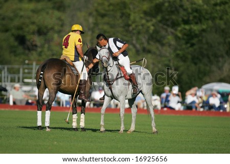SARATOGA SPRINGS - August 27: Official helps adjusting saddle for Polo Player during match at Saratoga Polo Club August 27, 2008 in Saratoga Springs, NY.