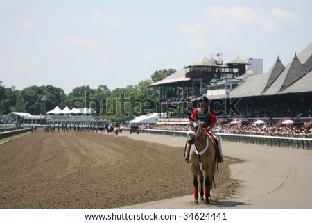 SARATOGA SPRINGS, NY- AUGUST 1: Outrider waits for horses warming up before the 1st race at Saratoga Race Track - August 1, 2009 in Saratoga Springs, NY.