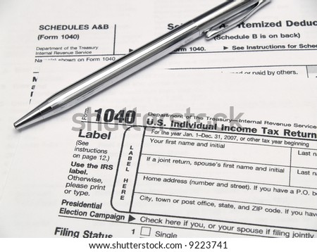 Income tax forms and a pen on a table.