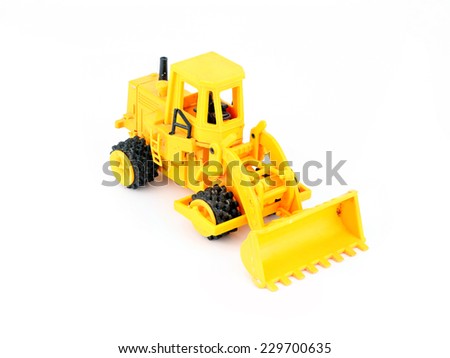 Old yellow toy tractor isolated on white background