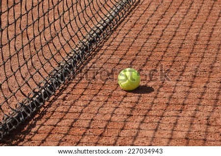 Tennis net with fast tennis ball on clay court