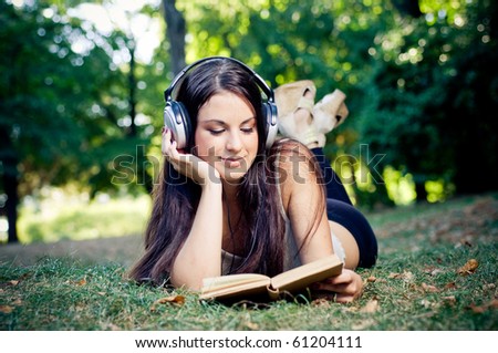 Beautiful girl reading and listening music