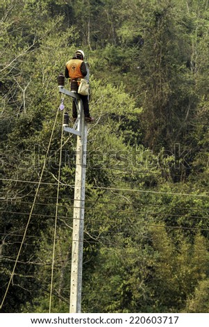 Electrician man on electric pole to install new electric cable