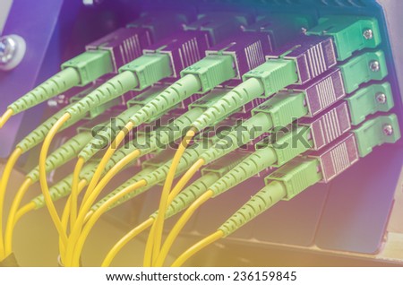 Server with set of green fiber optic cables in data center