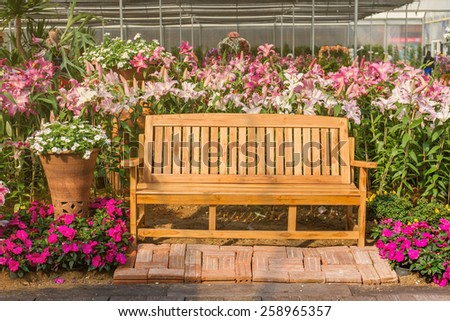 Wood bench in beautiful flower garden setting on side of pathway - Vintage effect style pictures