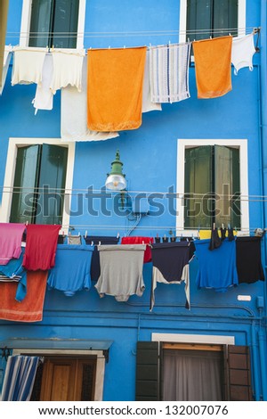 Laundry drying outside a blue house in Burano, Italy