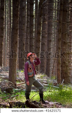 Forester standing among Douglas fir trees in the Pacific Northwest