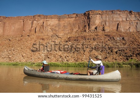 Mother and daughter canoeing on a calm blue river in the desert country of Utah