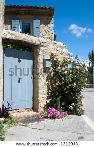 Front entrance to a small but charming French village home. I love the bits of colored glass protruding from the cement along the ledge.
