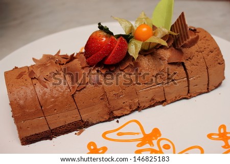 Plate of dark chocolate mousse cake on white plate