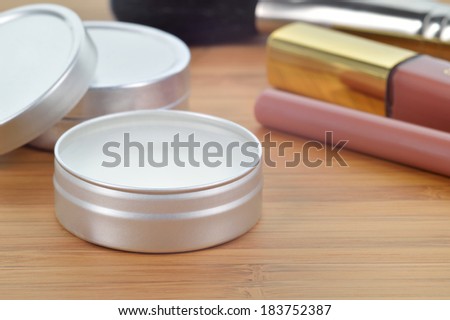 Pure shea butter in metallic tin on a wooden background. Perfect lip balm and beauty balm against of other lip cosmetics. Daily care for lips.