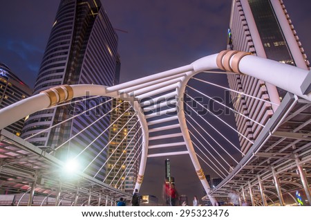 BANGKOK -JUNE 28: View of high buildings and public sky walk for transit between Sky Transit and Bus Rapid Transit Systems at Sathorn-Narathiwas junction at night on June 28, 2015 in Thailand.