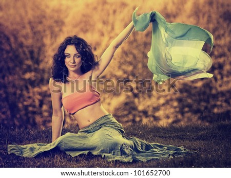 young beautiful woman holding scarf on a wind