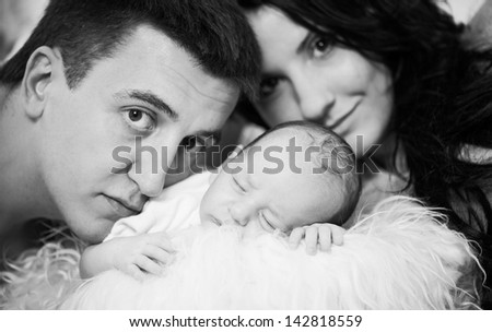 happy family portrait with sleeping newborn baby boy