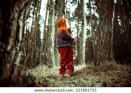 little girl looking back at fall forest