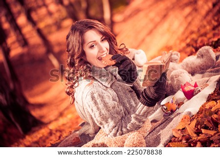 young cute brunet with cookie and tea at fall forest