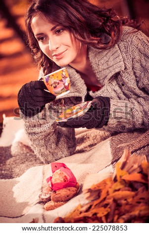 pretty brunet drinking tea at fall season forest
