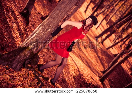 young sexy brunet in red dress at fall forest