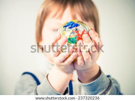 colorful glass ball in little boy hands