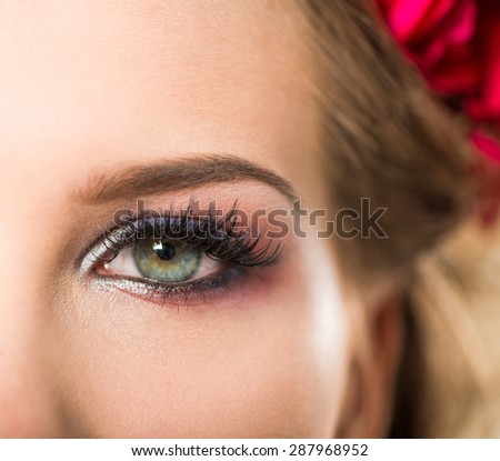 young woman open eye with makeup closeup