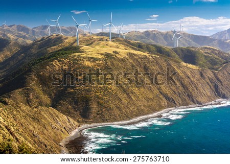 landscape with hills, ocean and wind turbines