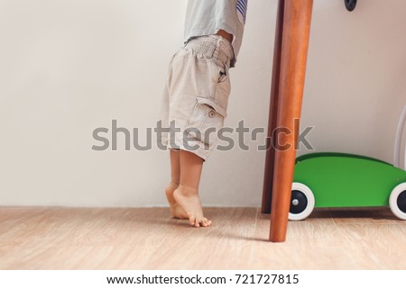 Similar – Image, Stock Photo Baby reaching for feet, dimpled baby hands, triangle print blanket and pants