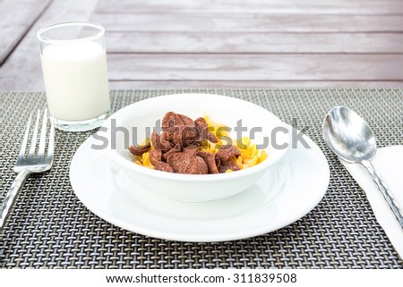 Breakfast with milk pouring in corn flakes