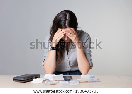 Personal Finance, the frustrated woman considers the costs, receipts and invoices, enter your expenses in the app for keeping track of the money. Family budget. Photo stock © 