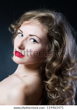 Portrait of a beautiful teen girl with long curly hairs and clean skin of the face - isolated on black