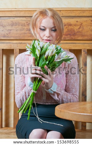 woman with cup of coffee and flawors in grey suit at cafe