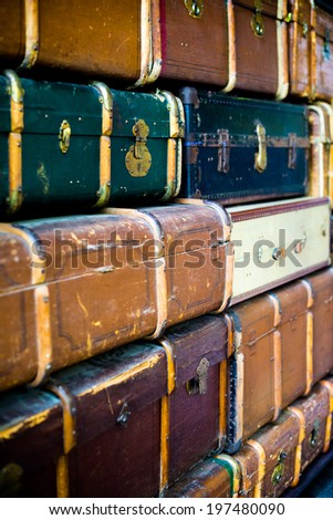 Abstract textured background created by a pile of old grungy cabin trunks with locks and reinforcing bars.