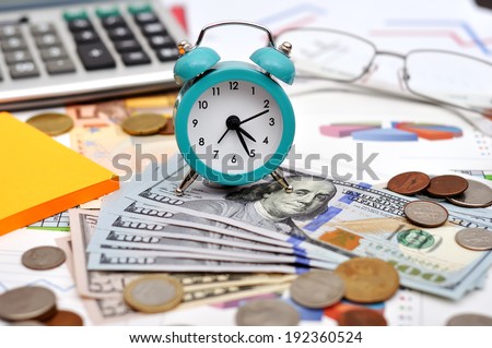 alarm clock, money and calculator on the table
