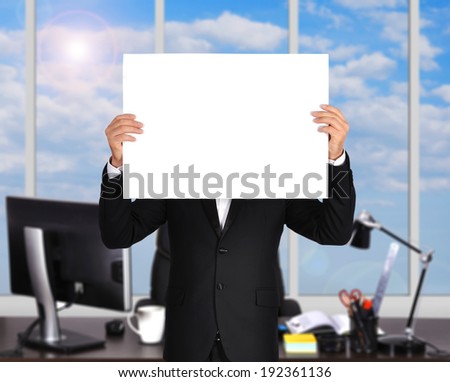 businessman standing in office and holding  poster