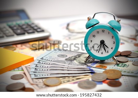 alarm clock, money and calculator on business table