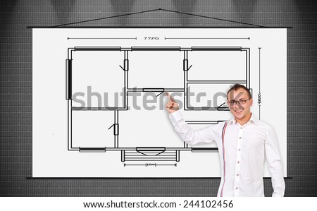 cheerful businessman pointing to a poster with drawing blueprint