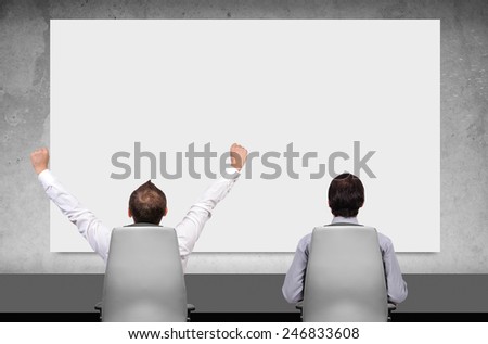 two businessman in boardroom and looking on blank poster