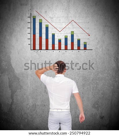 businessman thinking and looking to falling chart on wall
