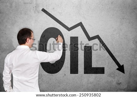 businessman drawing falling oil chart on concrete wall