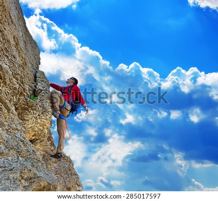 Young man climbing on rock, and blue sky