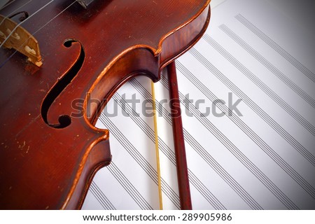 Old-fashioned violin with bow and notes, close up