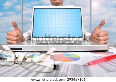 businessman showing thumb up and blank laptop on table