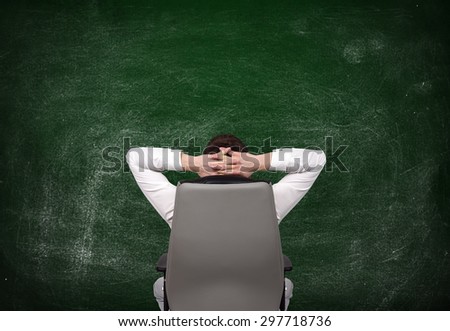 relaxing businessman looking at blank chalk board