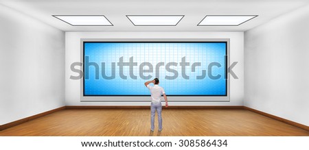 businessman looking at blank plasma tv on the wall in boardroom