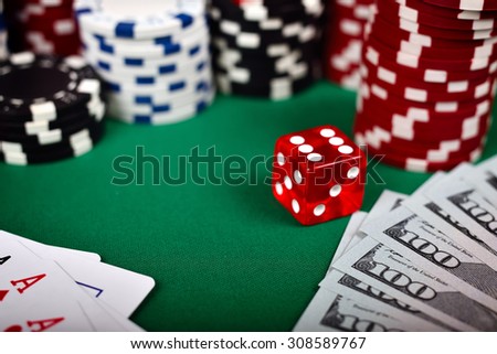 Poker chips, cards, dollar and dice on green table